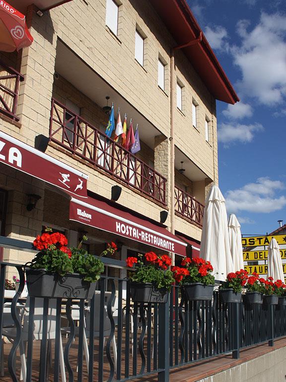 Fachada del Hostal Ruta del Porma en Puebla de Lillo, con las montañas al fondo